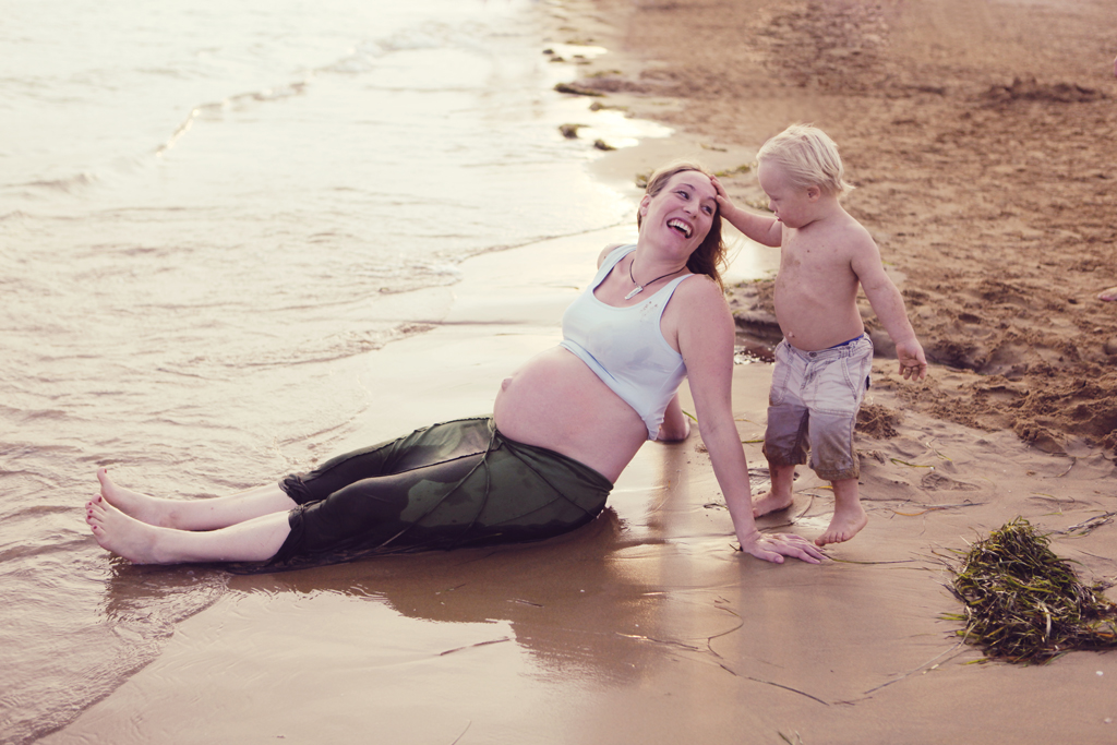 Pregnant woman with toddler on a beach