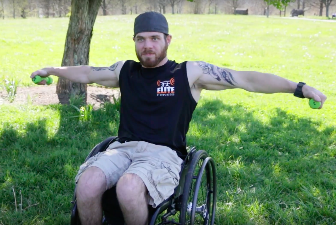 Athletic man in a wheelchair lifting weights.