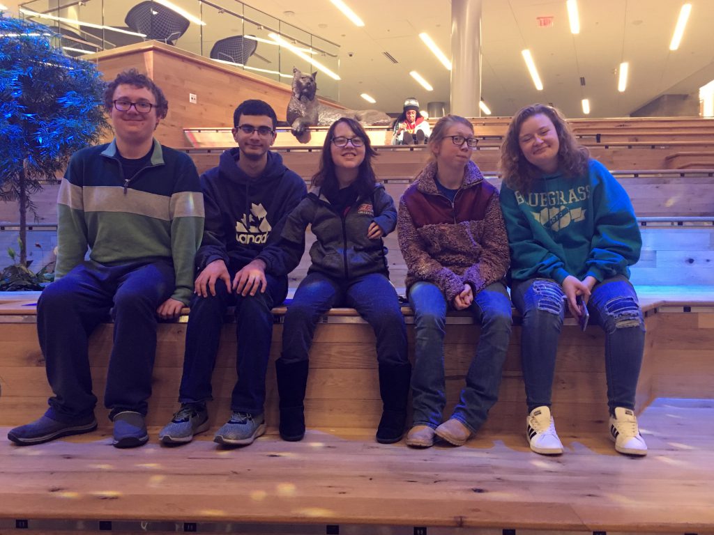 Five students with disabilities sitting on a bench, 2 boys and 3 girls