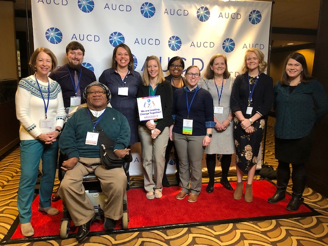 10 people in front of AUCD banner