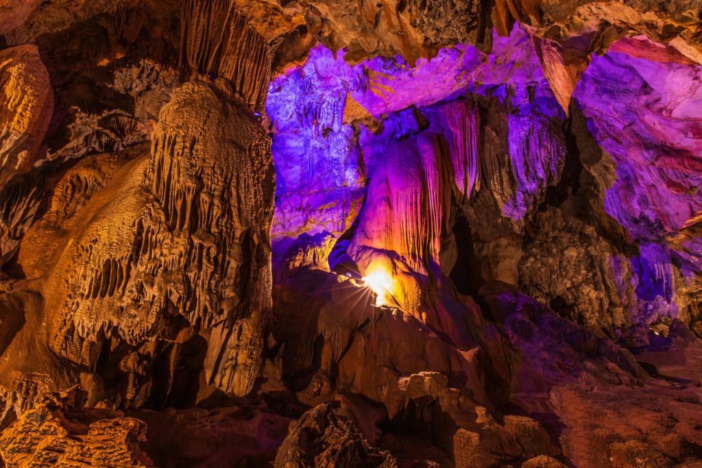 Rock formations in Mammoth Cave with a purple backlit glow
