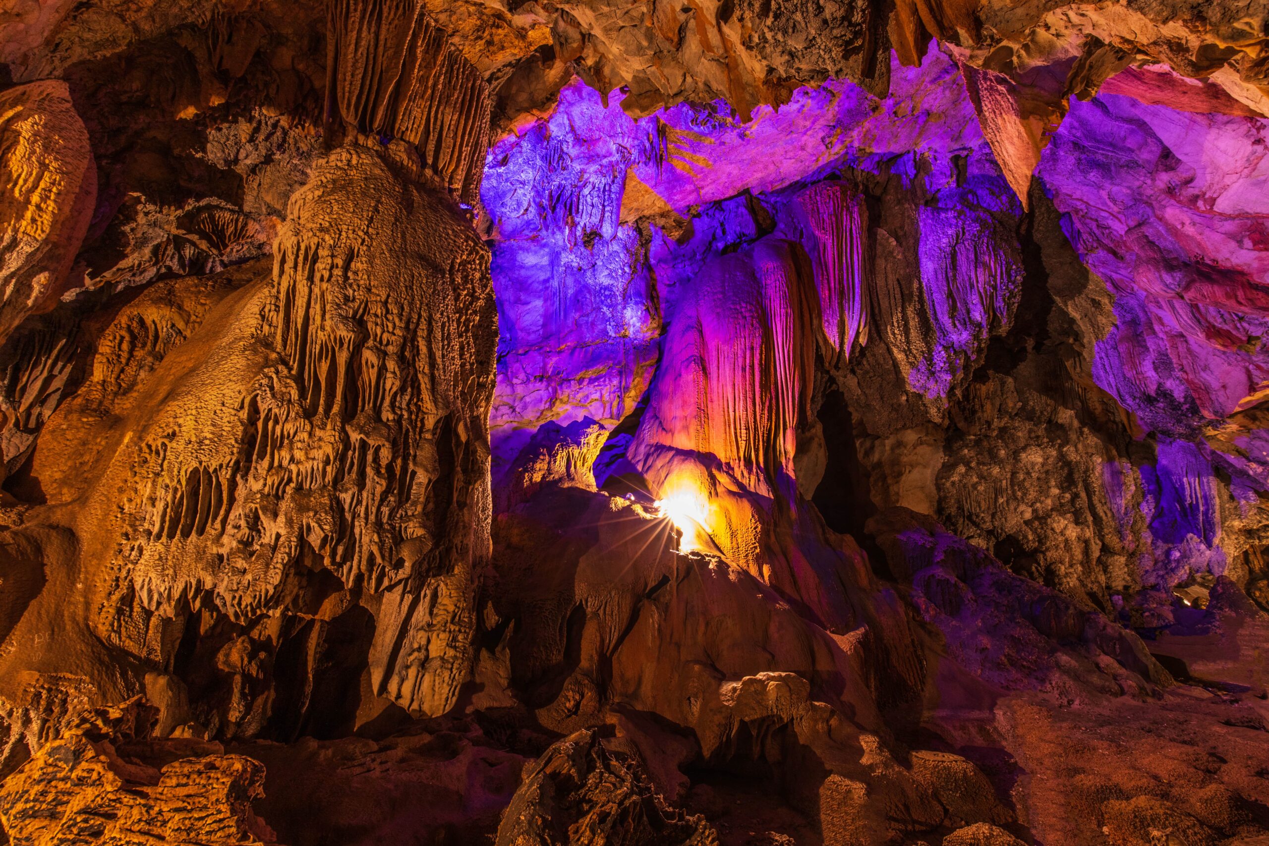 Rock formations in Mammoth Cave with a purple backlit glow