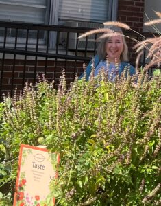 Photo of the garden featuring a smiling Kathy Sheppard-Jones